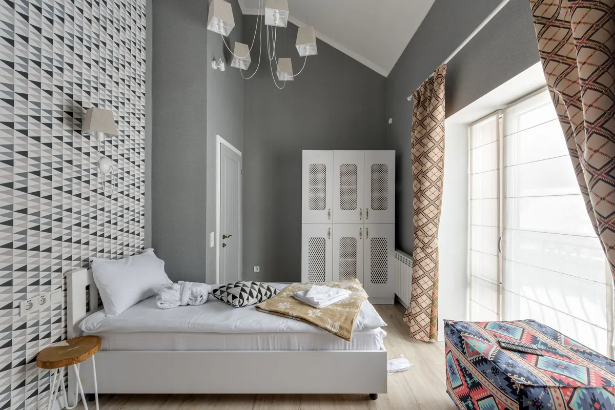 Stoere kinderkamer met grijze muren en een wand met grafisch behang in zwart en wit